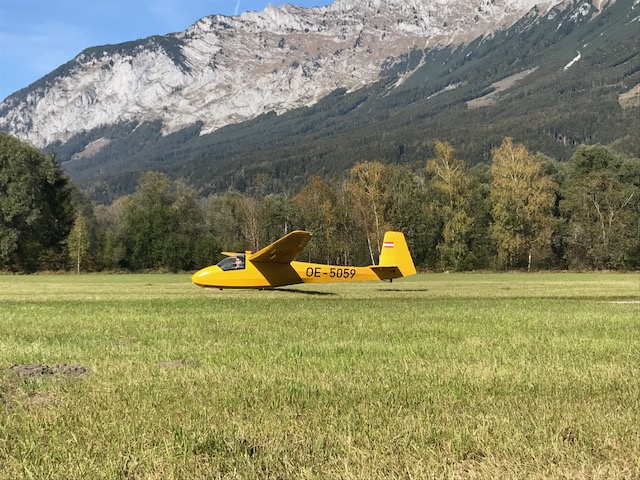 Gelbes Segelflugzeug bei der Landung vor dem Grimming